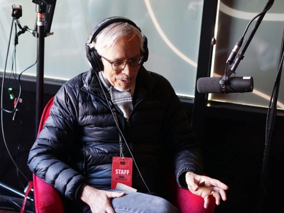 man wearing headphones in front of a microphone