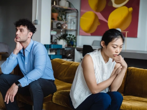 two people facing away from each other on a couch