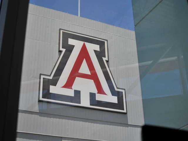 A large red, white and blue block 'A' is affixed to the side of a metal wall. The photo is taken through a window, casting a slight reflection.