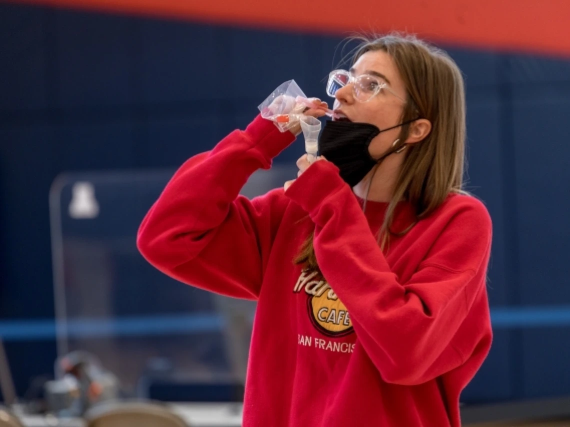 young woman taking a saline gargle test