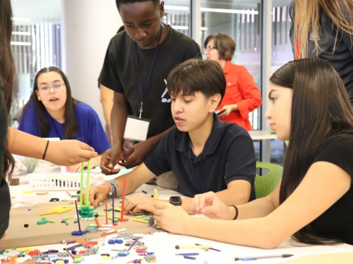 students sitting around a table working together to build something